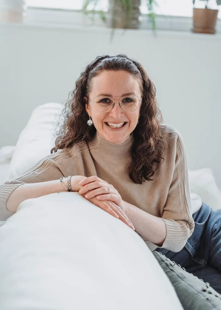 Coaching für Frauen mit Beatrice Häcki lächelnd auf einem Sofa in heller, entspannter Atmosphäre, einladend und nahbar.