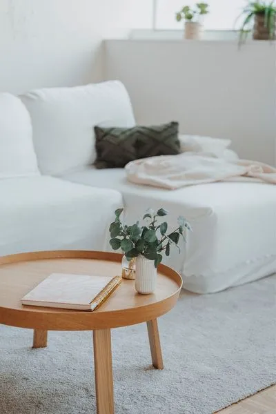 Heller Wohnraum mit Sofa, Holztisch, Notizbuch und Eukalyptus in ruhiger Atmosphäre