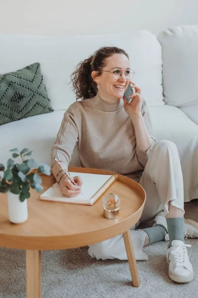 Coach Beatrice Häcki im Gespräch am Telefon mit Notizbuch in heller ruhiger Atmosphäre